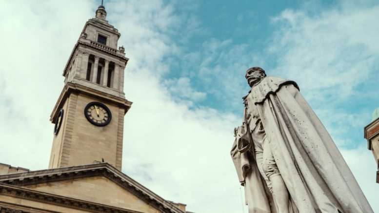 An image of a statue and Hull&#039;s Guildhall