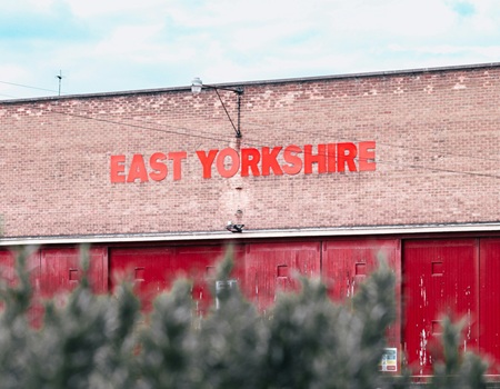 An old building used to store buses featuring an East Yorkshire sign